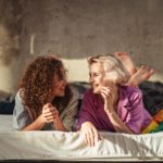 two women laying on bed together- trauma and the lgbt community