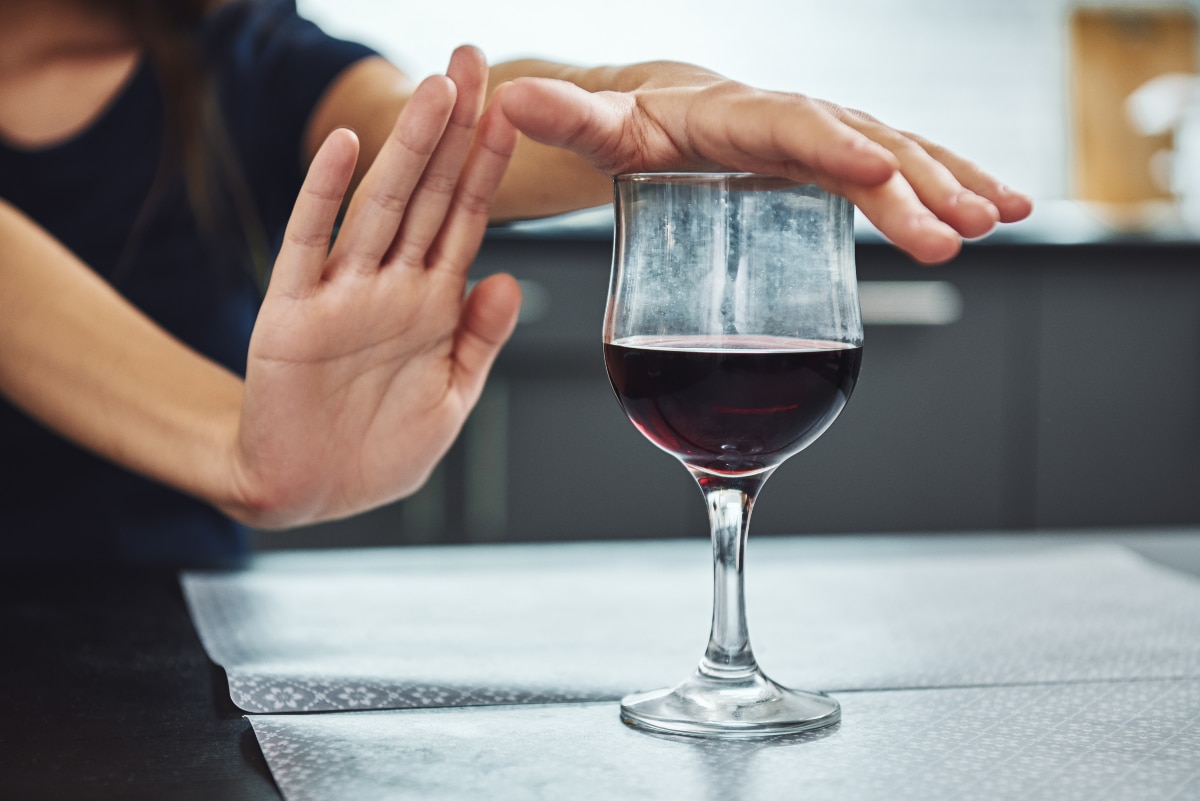 Woman declining alcohol because she knows the benefits of quitting alcohol