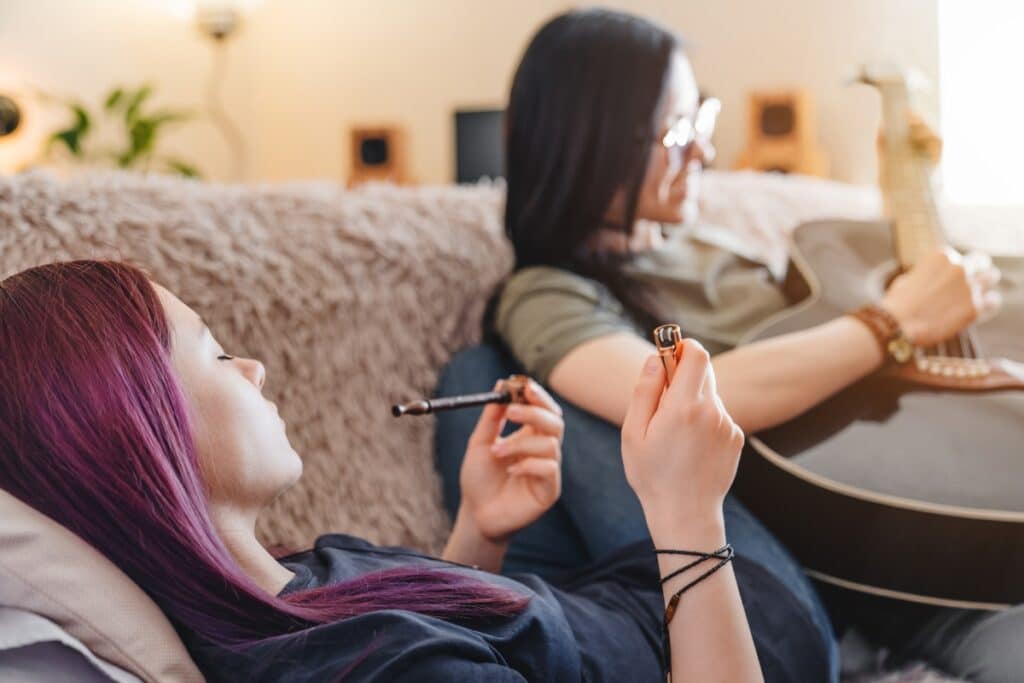 A woman and her girlfriend relaxing, but engaging with drugs, primarily marijuana.
