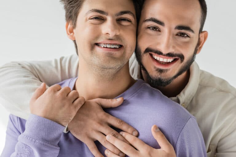 two gay men in the lgbtq+ community smiling at camera - sexualized drug use in the lgbtq+ community chemsex