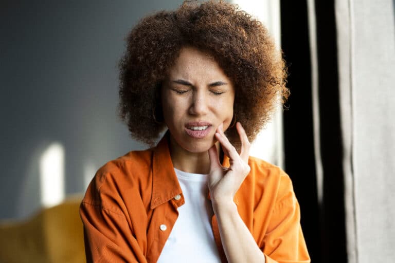 woman holding jaw suffering with bruxism - cocaine jaw in los angeles california