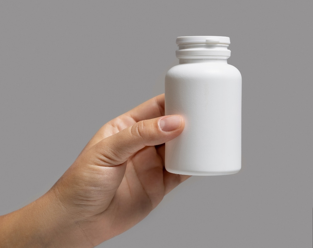 woman holding blank white pill bottle - adderall abuse