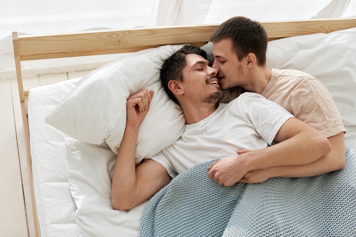 gay couple laying on bed at home - sex and intimacy in recovery