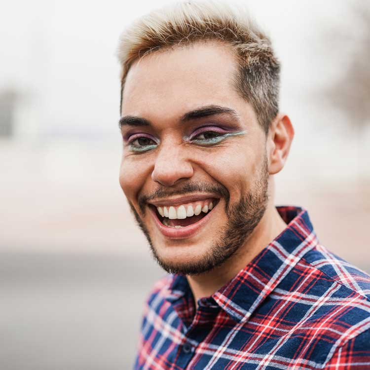 Gay man with eye shadow smiling and very happy with his rehab therapy.