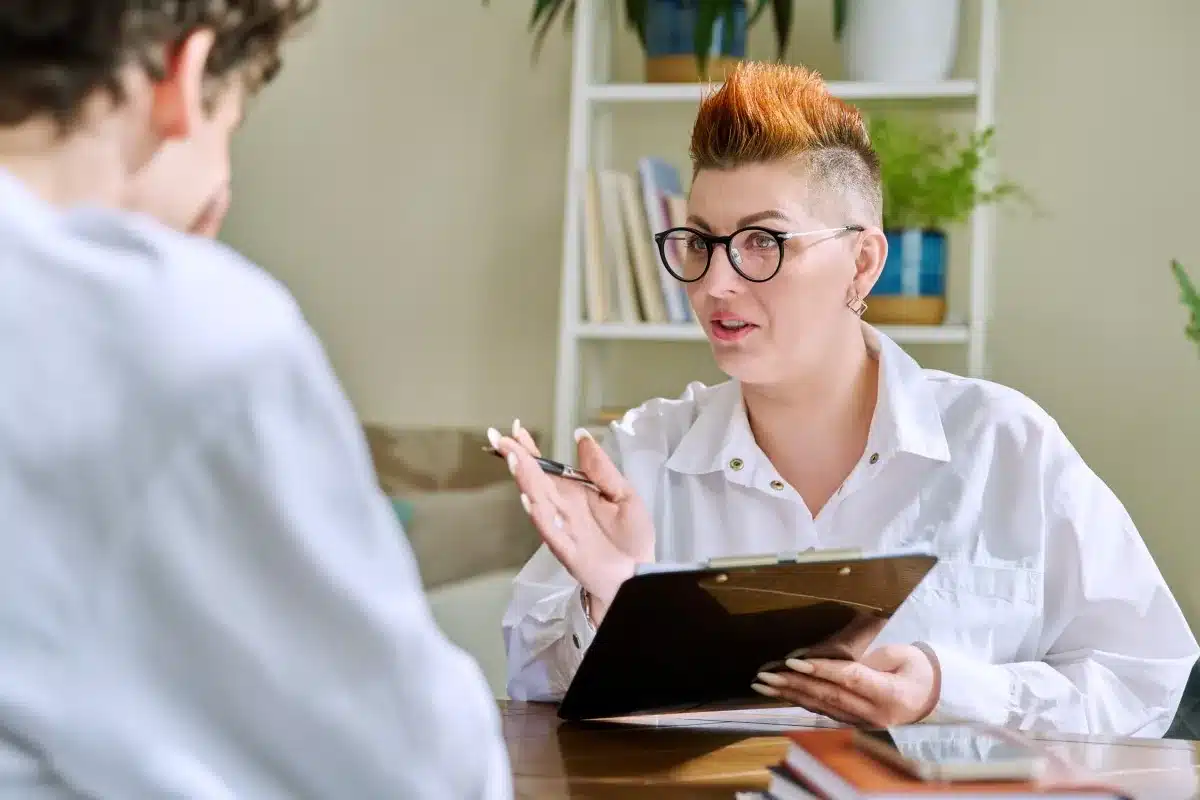 Compassionate counselor discussing MAT medication options with an LGBTQ+ client during an opioid recovery session